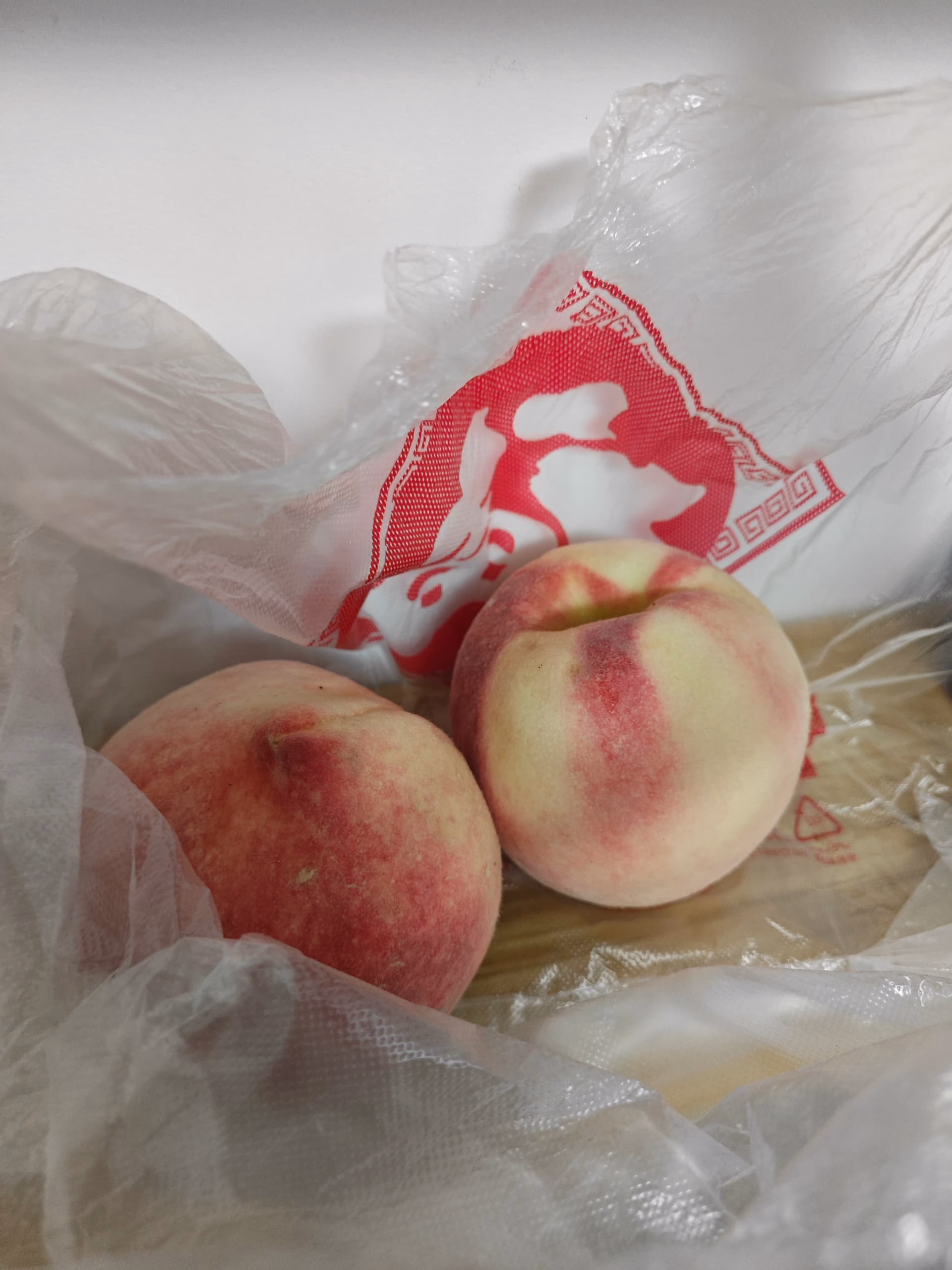Two peaches in a clear plastic bag. (由 AI 生成标题)