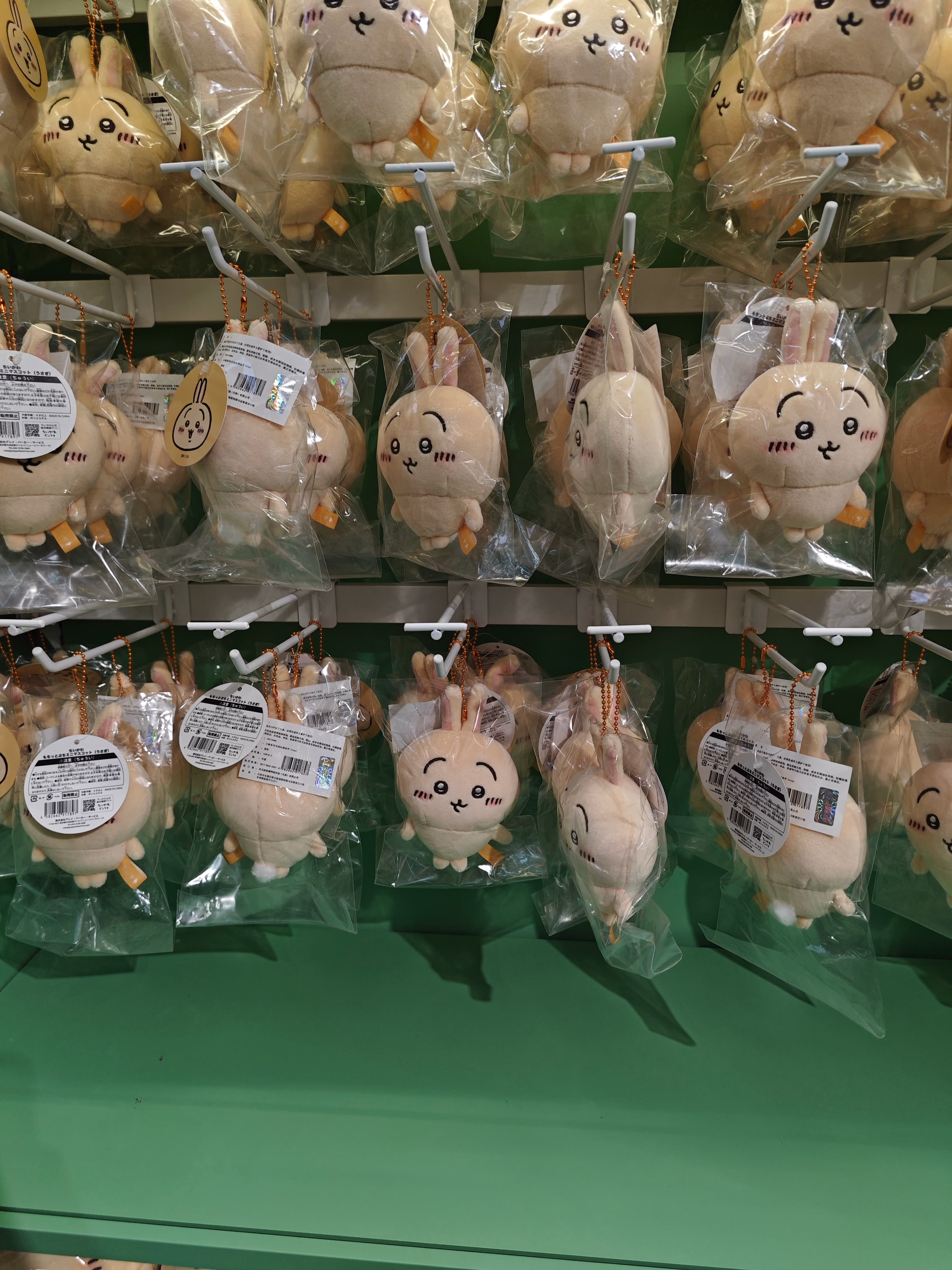 The image shows multiple plush toys, individually wrapped in clear plastic bags, hanging from a display. (由 AI 生成标题)