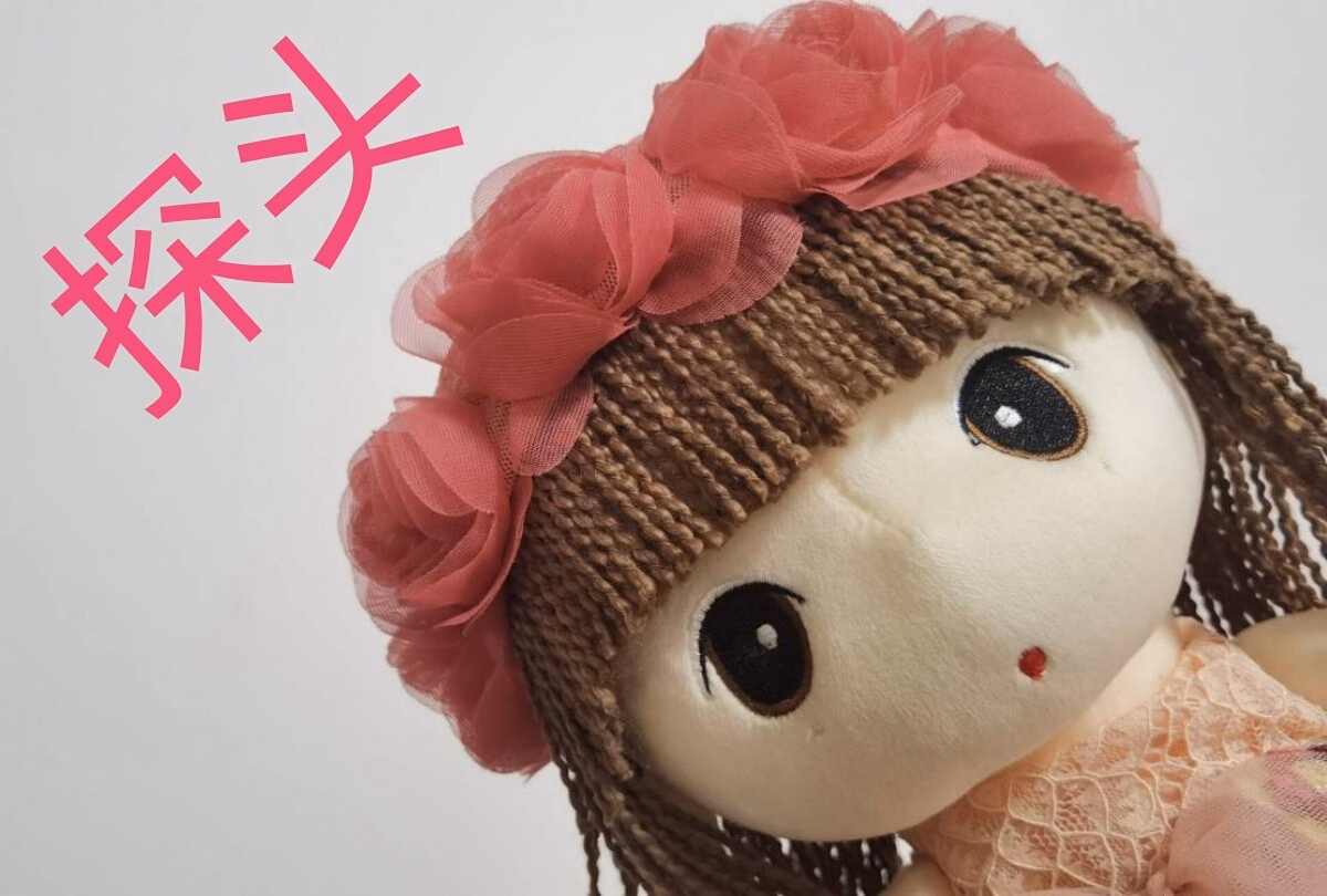 This is an image of a cute, brown-haired doll with a pink flower in her hair, wearing a brown wig, and it has pink Chinese characters in the background. (Captioned by AI)